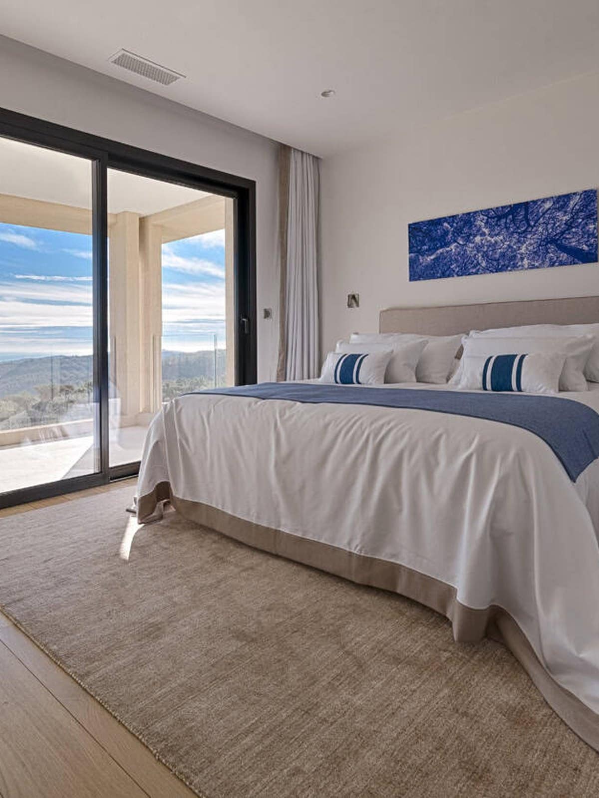 A slim-framed Cortizo slider running the full width of a bedroom wall